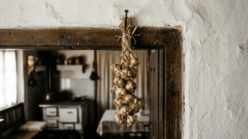 A braid of garlic hanging above the doorway of a traditional Serbian village kitchen
